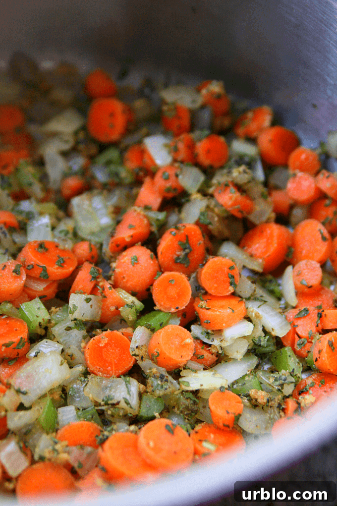 Vegetables being sautéed in a saucepan.