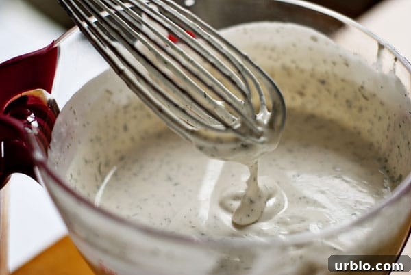 ranch dressing made in a large measuring cup with wire whisk
