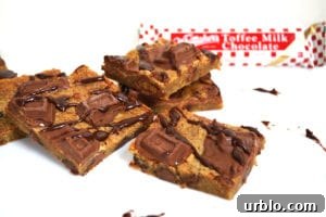 Whittakers Toffee Milk Chocolate Bars. Soft, dense and chewy toffee slice with chocolate chips and Whittakers Toffee Milk Chocolate pieces throughout. Topped with more Whittakers Toffee Milk Chocolate pieces and melted chocolate! Recipe on Lights, Camera, BAKE! #WhittakersToffeeMilkBlock #toffeebars #chocolatetoffeeslice #softtoffeebars #milkchocolatebars