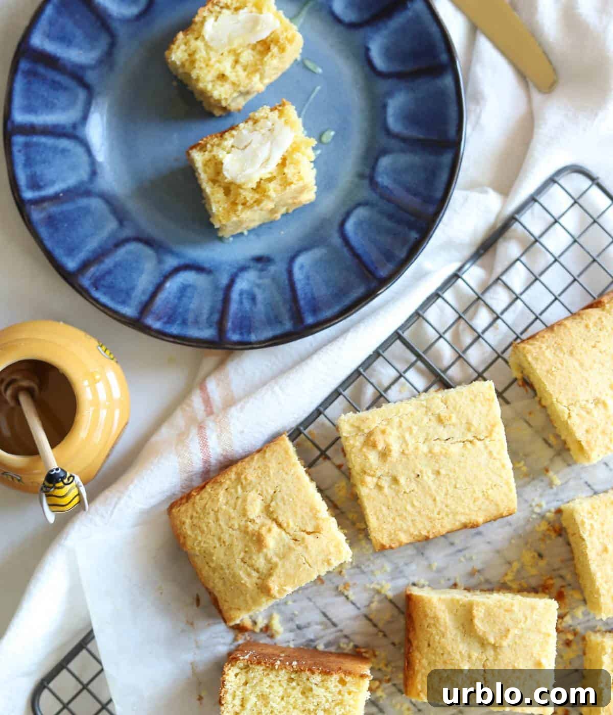 Moist Fluffy Cornbread Recipe Without Buttermilk 2 Sliced cornbread on blue plate with butter and honey.