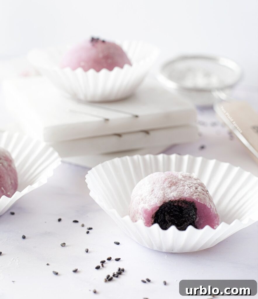Front view of ube mochi bitten in half to show interior.