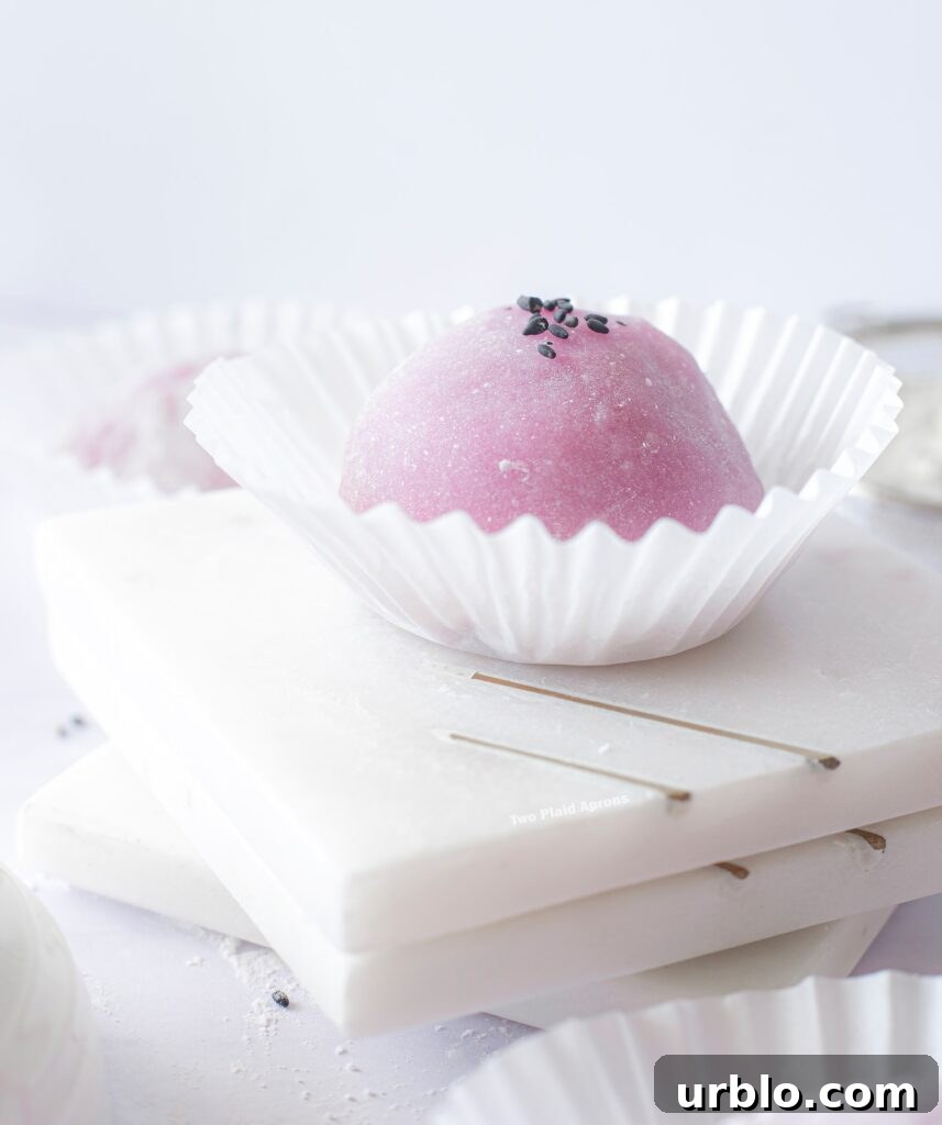 Close up view of a ube mochi with black sesame filling.