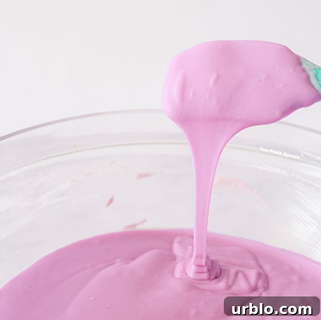 Ube mochi batter flowing from a spatula to show consistency.