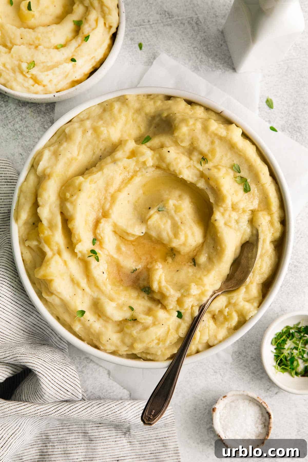 dairy-free potatoes in a serving bowl with a spoon scooping into the bowl.