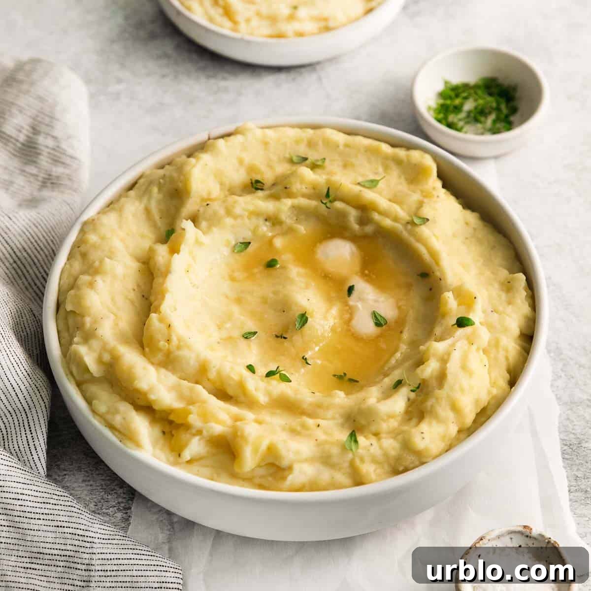 daipotatoes in a serving bowl with a spoon scooping into the bowl.