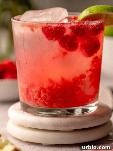 A raspberry cocktail on coasters.