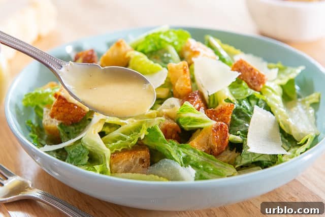 Caesar Salad Recipe - in Blue Bowl with homemade Dressing Spooned On top