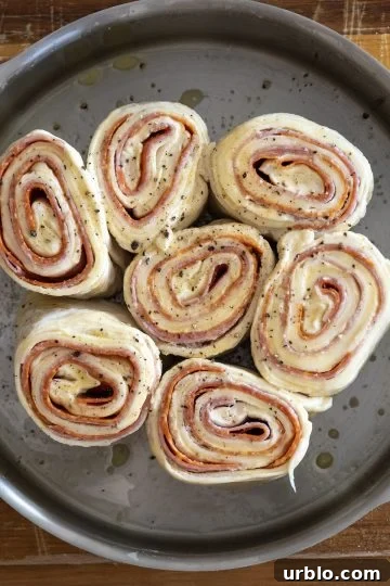 dough cut into equal length rolls and placed on their sides in a cake pan. Leaving about an inch or two on the sides.