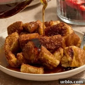 Maple syrup being poured over French toast casserole.
