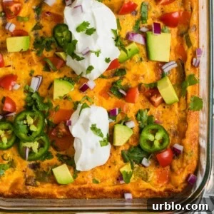 Chorizo egg bake in glass baking pan topped with sour cream, jalapeño, avocado, etc.