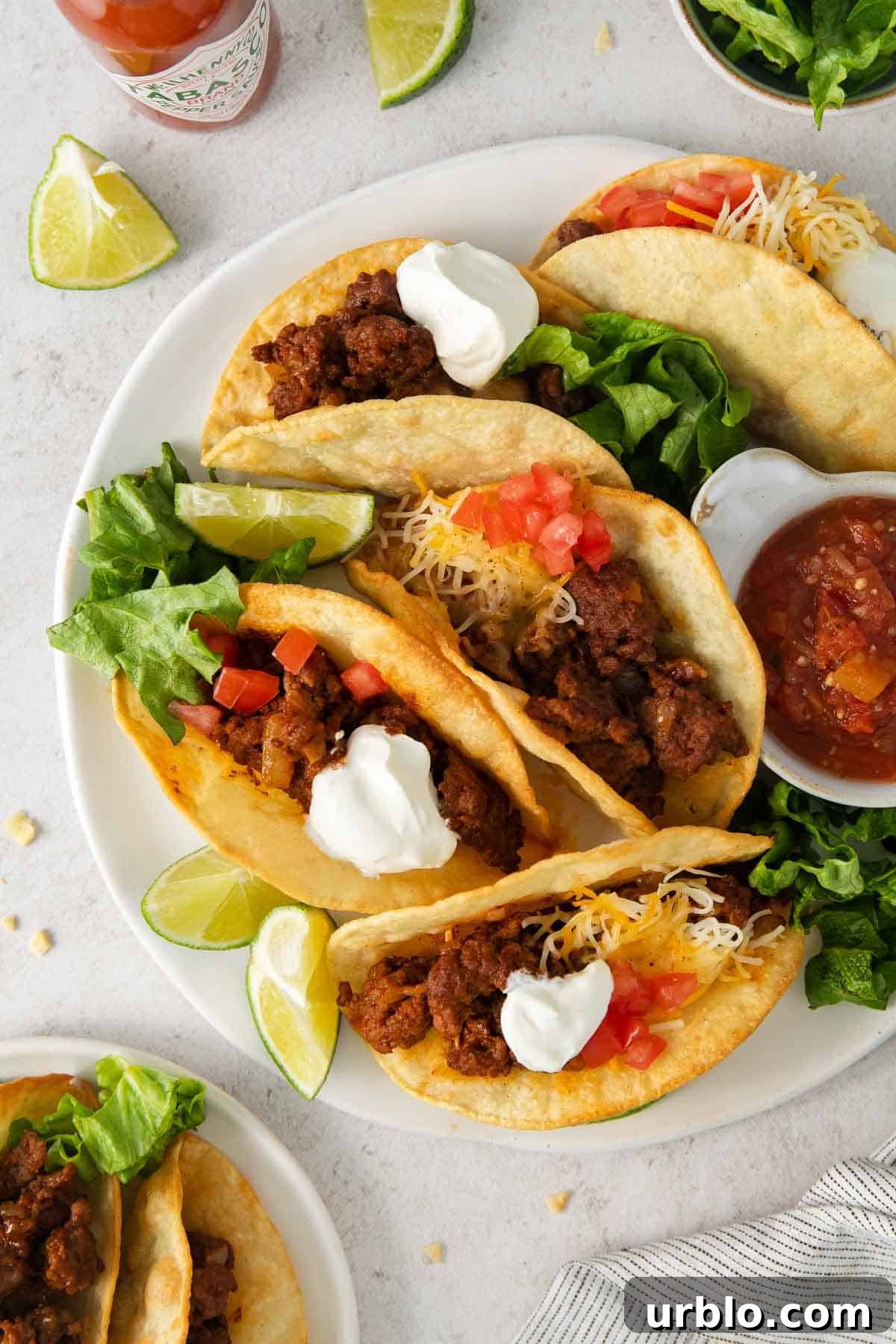 Gluten-free tacos on a plate with toppings.
