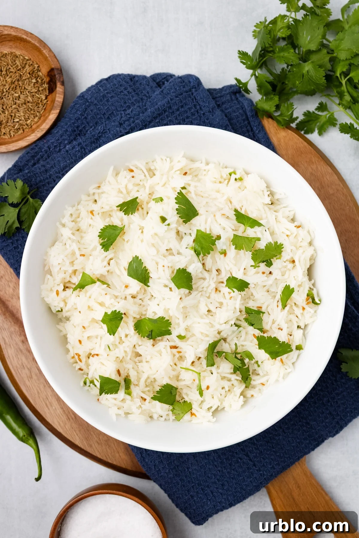 An overhead image of topping the cooked rice with fresh cilantro. 