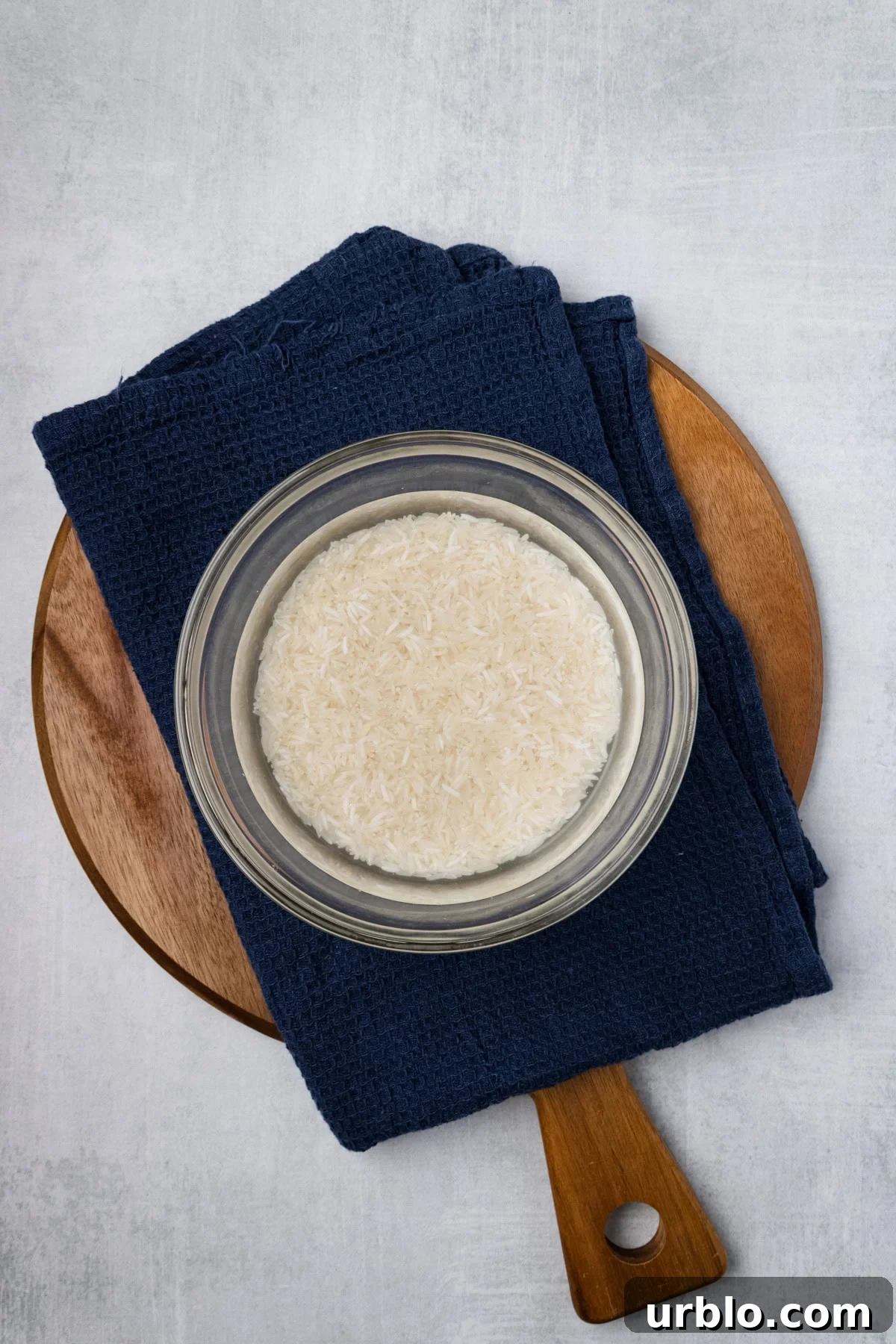 An overhead image of soaking rice in a bowl with water.