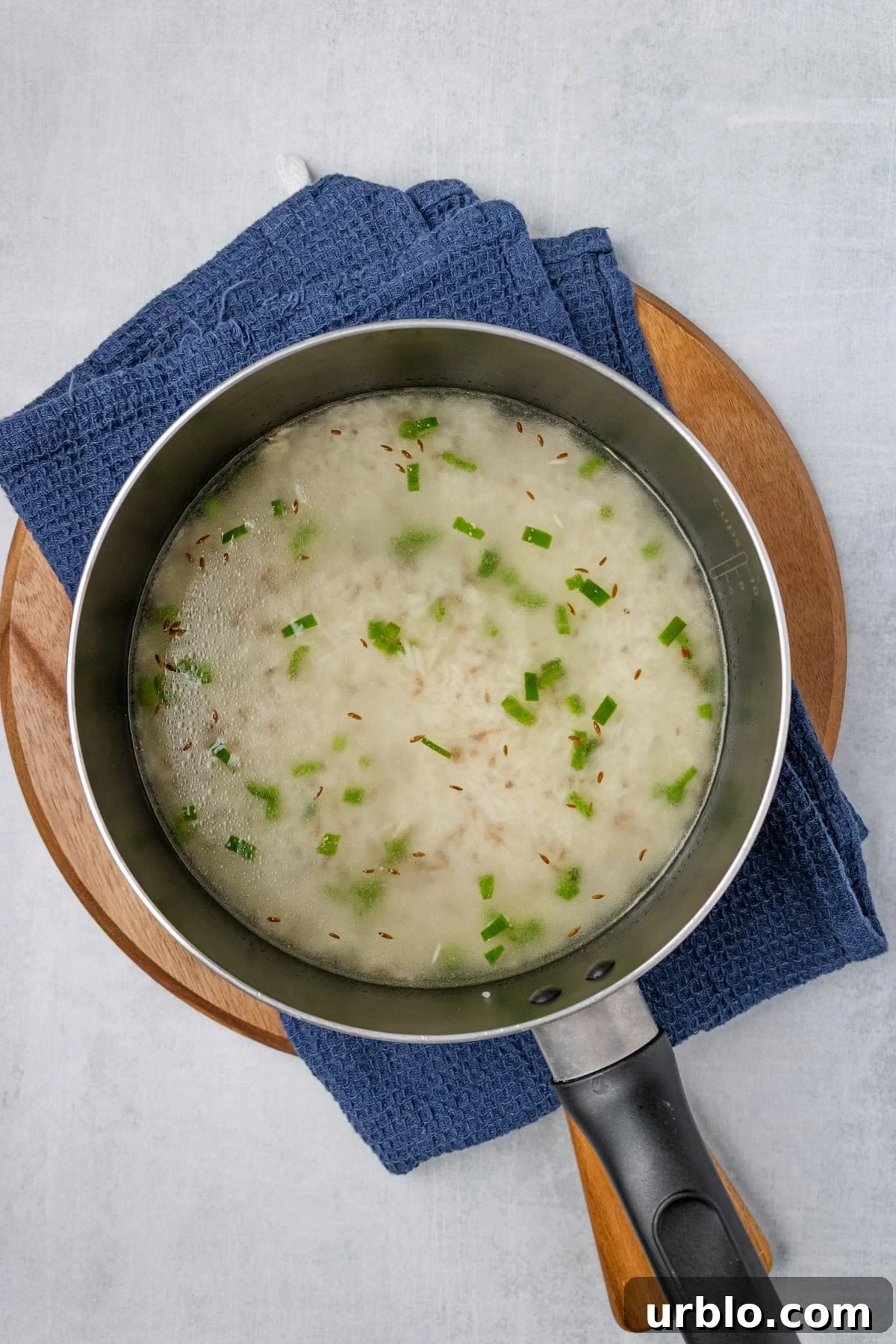An overhead image of adding rice to the skillet.