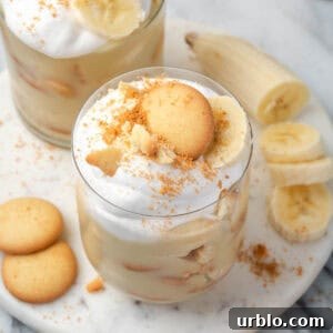 Two glasses of gluten free banana pudding sitting on a marble tray.