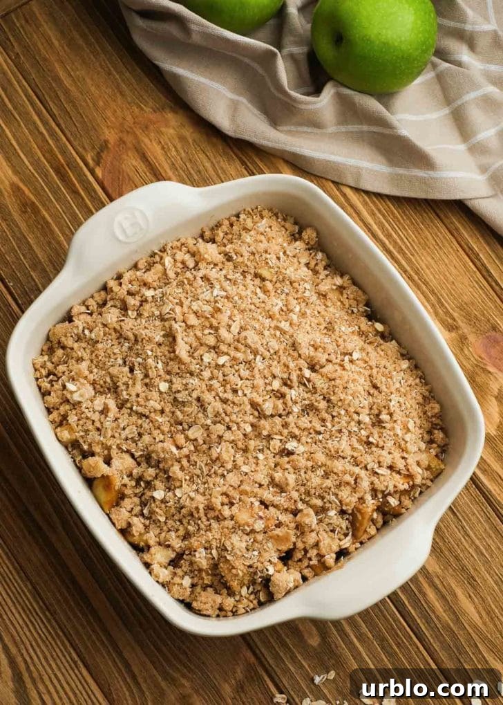 crumble topping being added to white baking dish