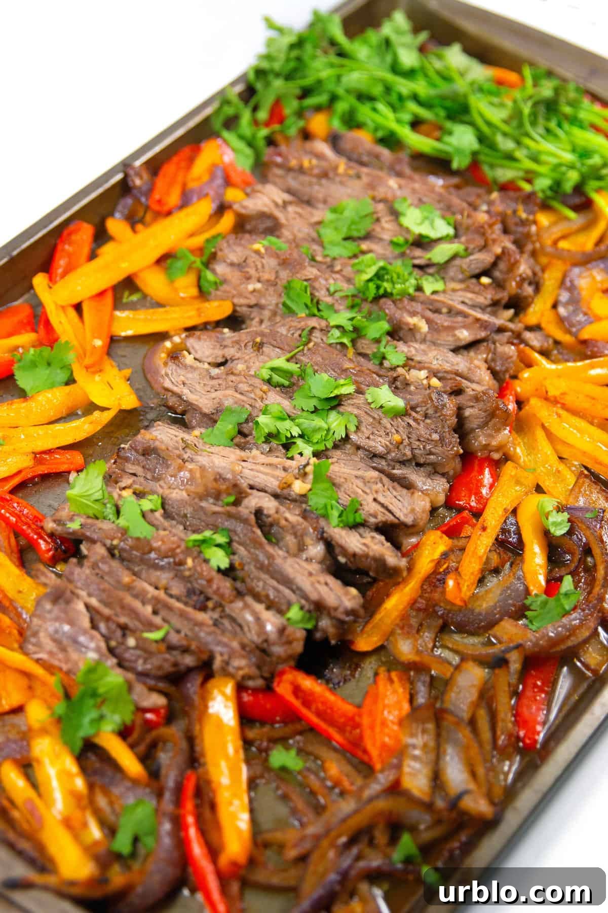 pan of sliced cilantro lime sheet pan fajitas with cilantro