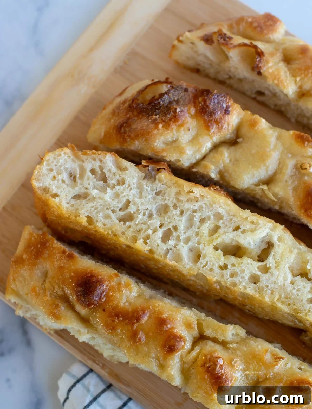 Slices of honey butter sourdough focaccia on a cutting board.