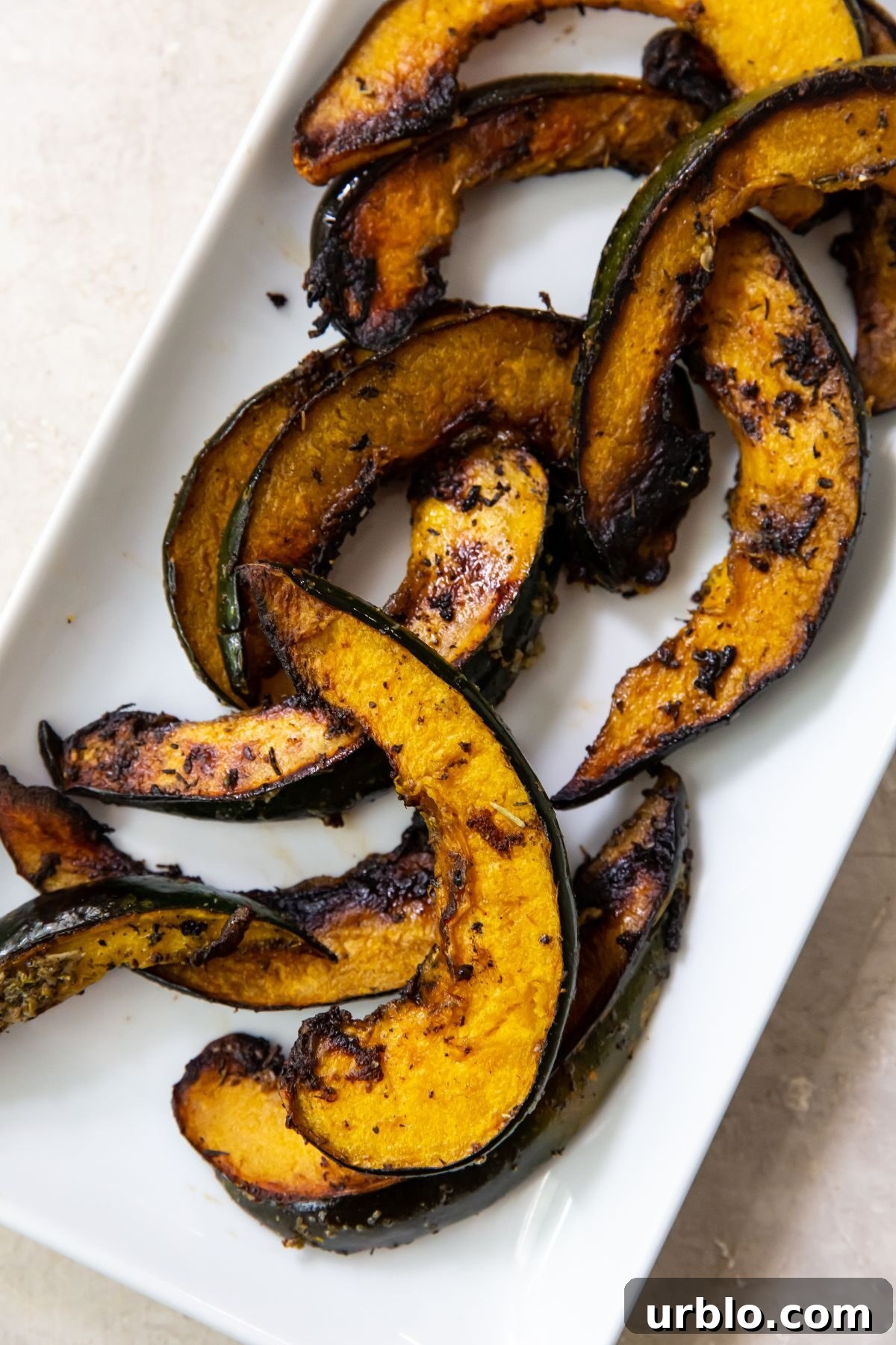 Grilled acorn squash on a white rectangular plate