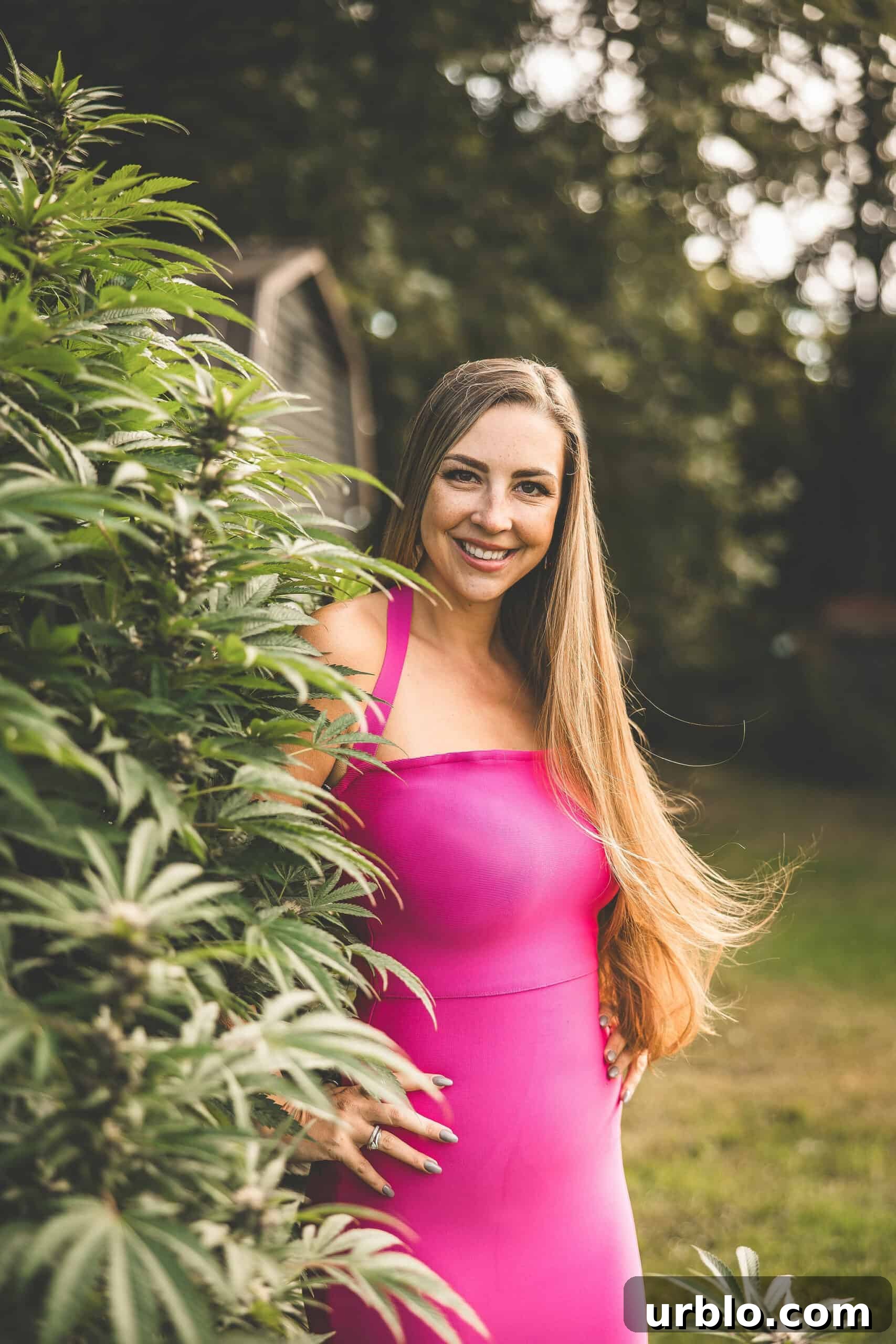 A picture of Emily Kyle with a growing cannabis plant.