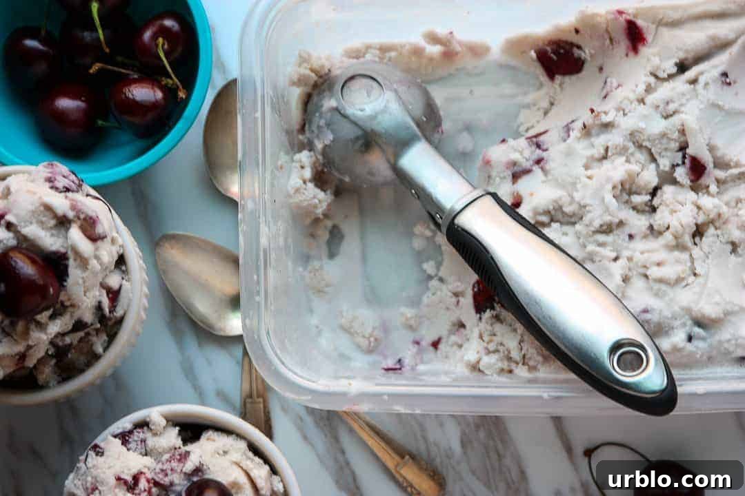 Homemade Cherry Amaretto Ice Cream Recipe 7 Ice cream being scooped out of a tub into bowls