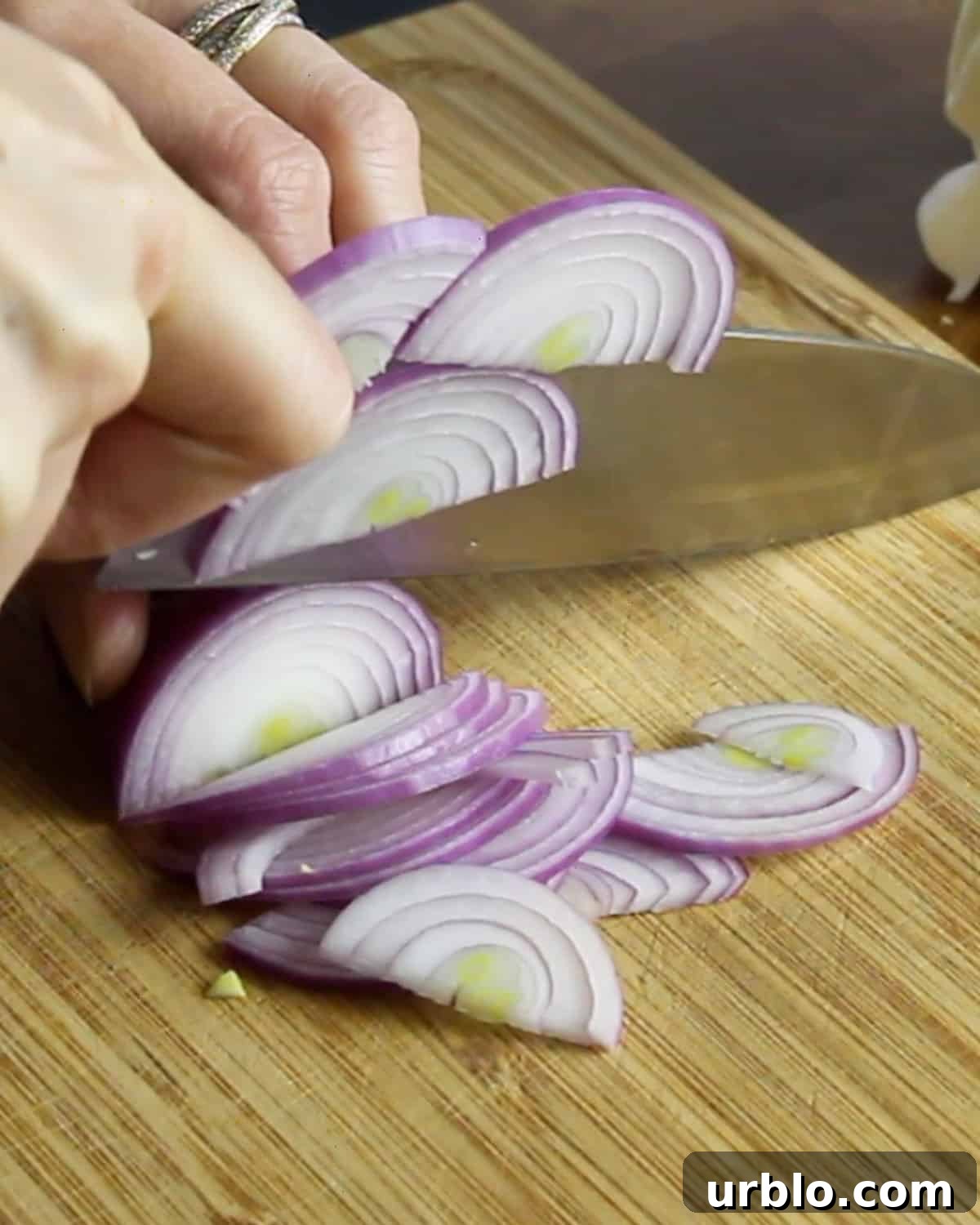 Photo of slicing red onions on a chopping board.