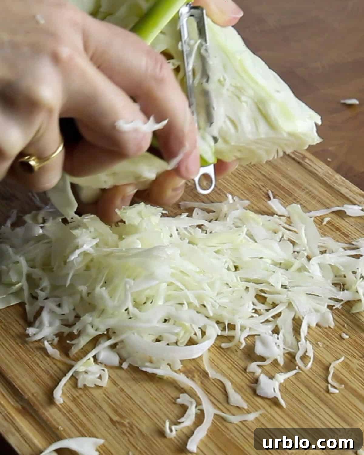 Photo of shredding cabbage on a chopping board using a Y-shaped peeler.