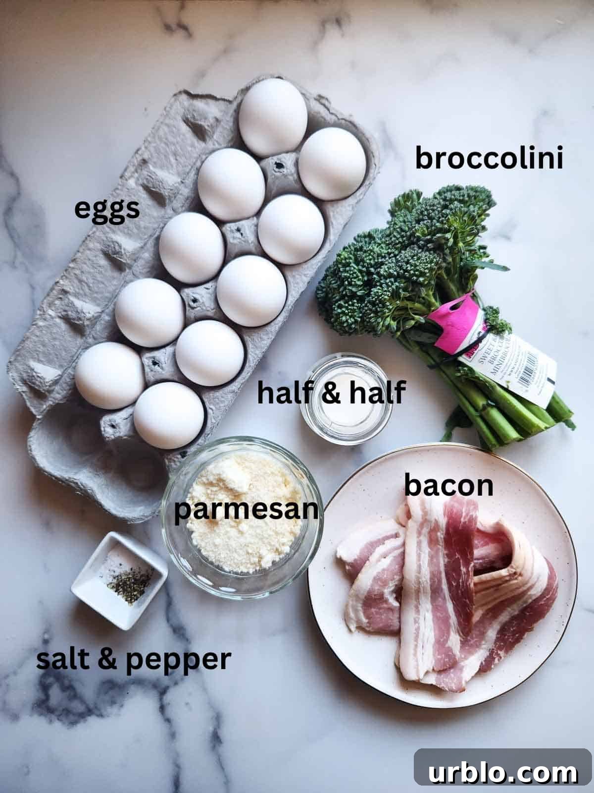 Overhead view of broccolini frittata ingredients on white marble.