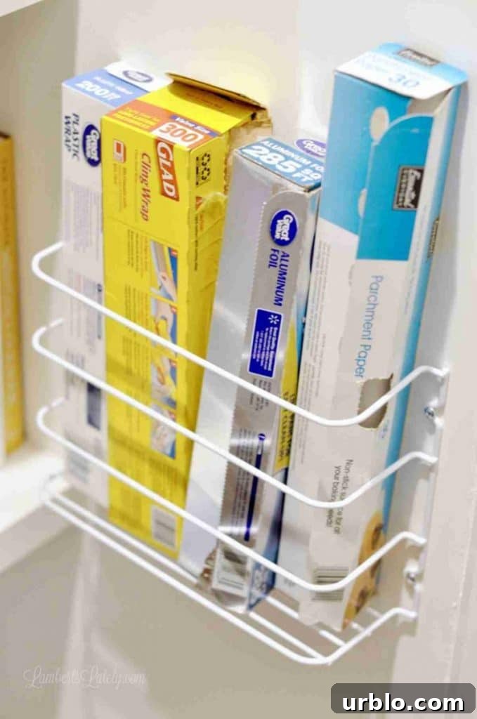 rack holding aluminum foil and plastic wrap on a wall.