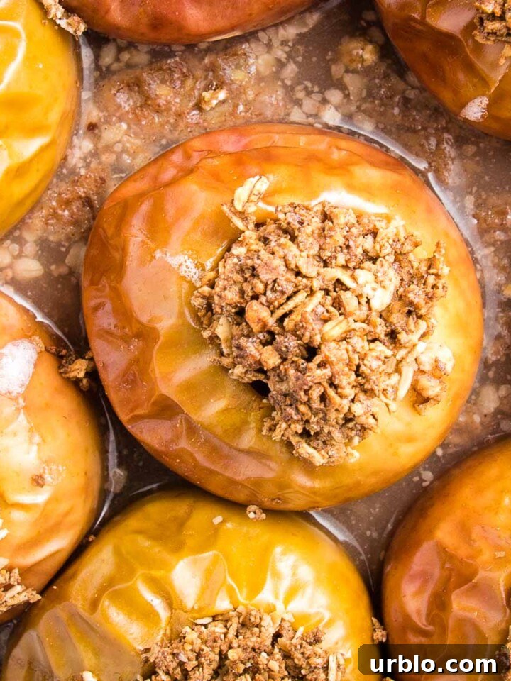 Close up of baked apples, stuffed with oatmeal in a glass pie plate.