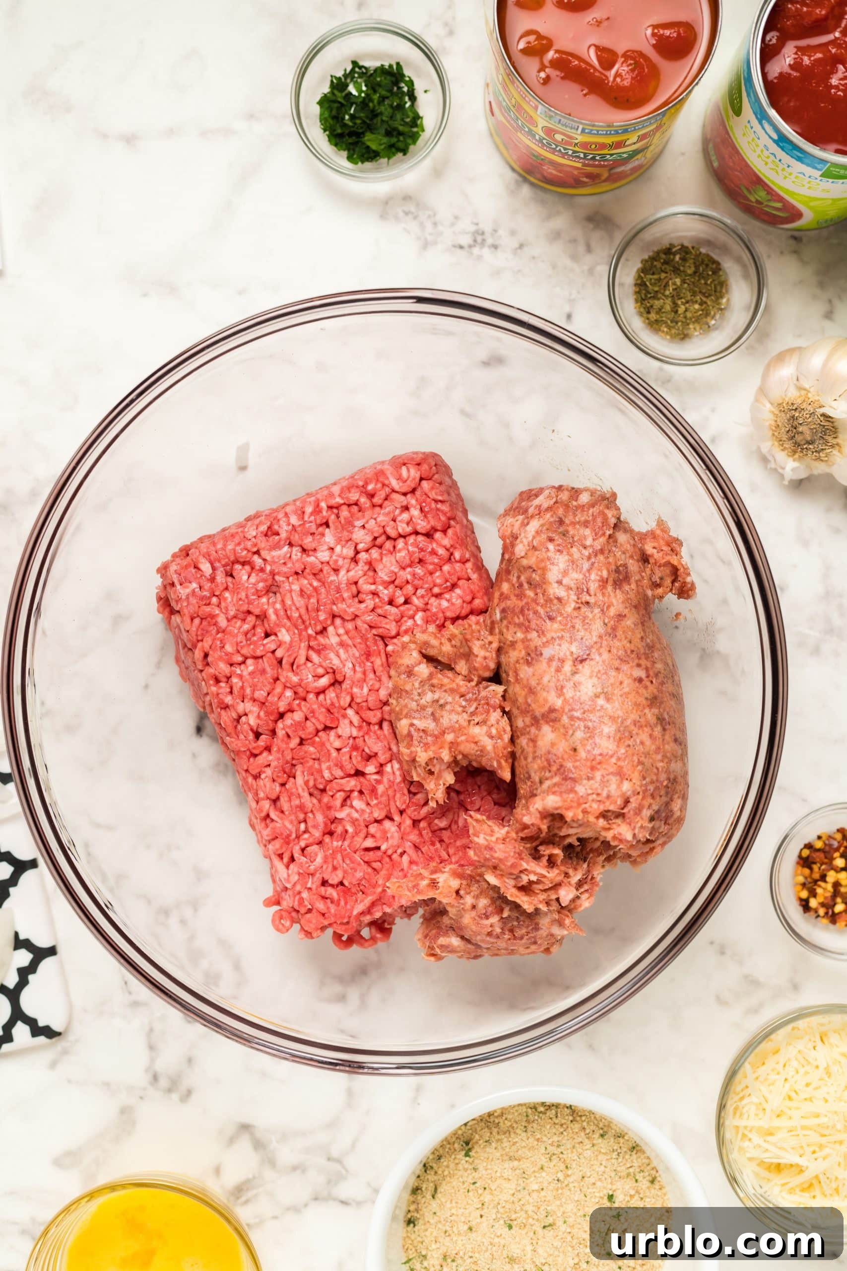 Ingredients for meatballs on a marble countertop.