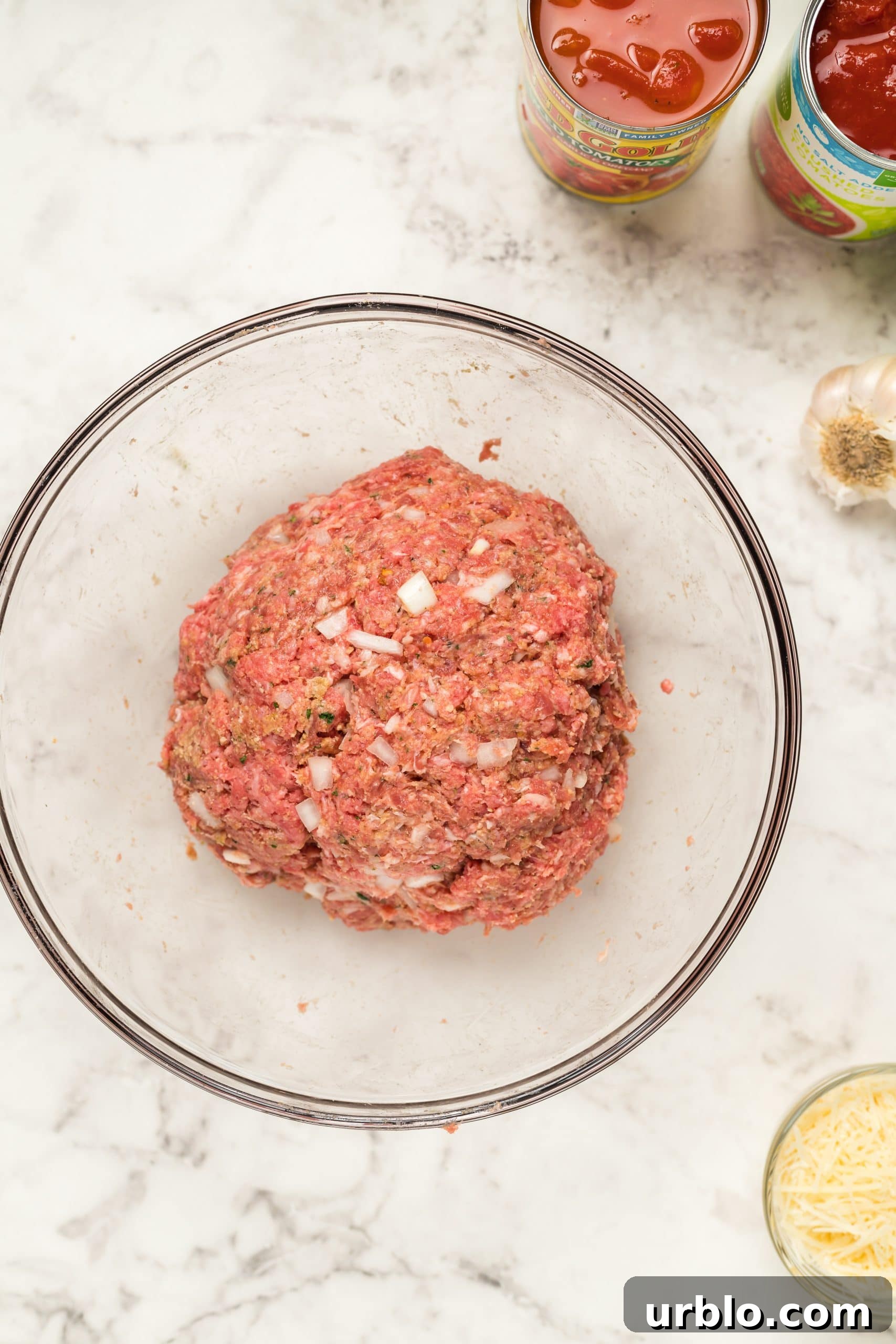 Ingredients for easy meatball subs arranged in a glass bowl alongside other components.