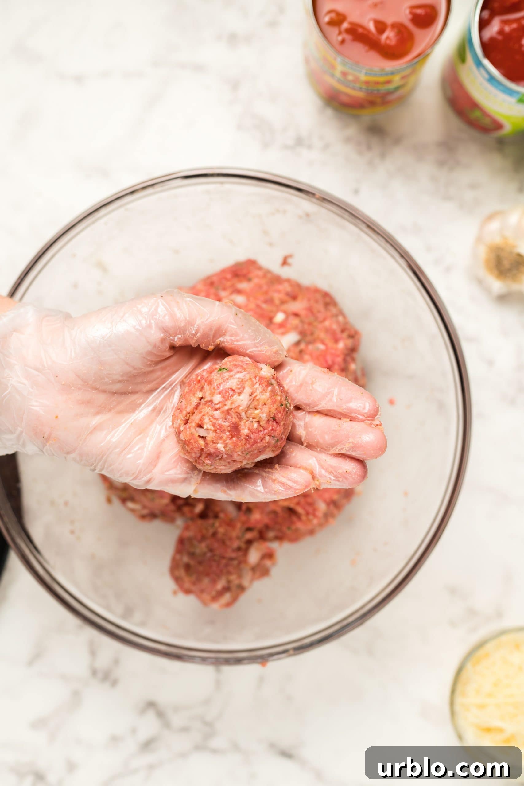 A hand is holding a bowl of meatballs, perfect for making easy meatball subs.