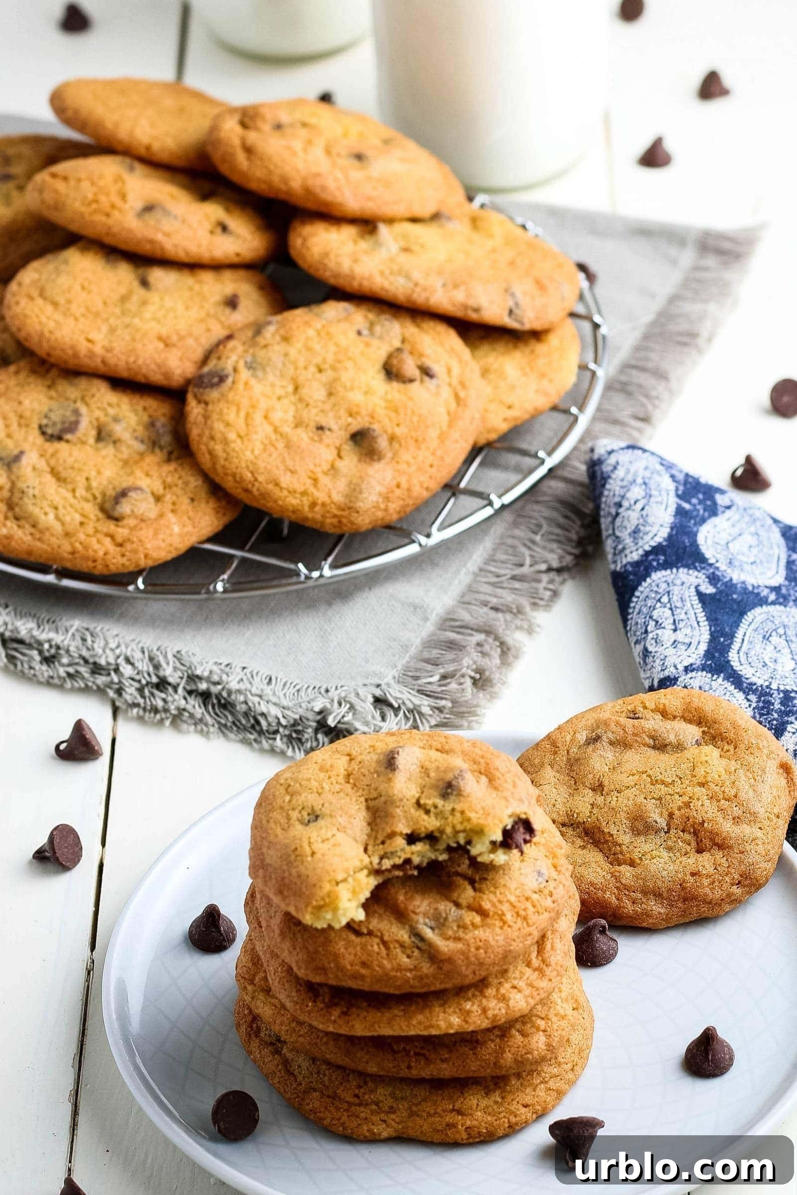 stack of air fryer chocolate chip cookies next to the rest of the batch on a wire rack