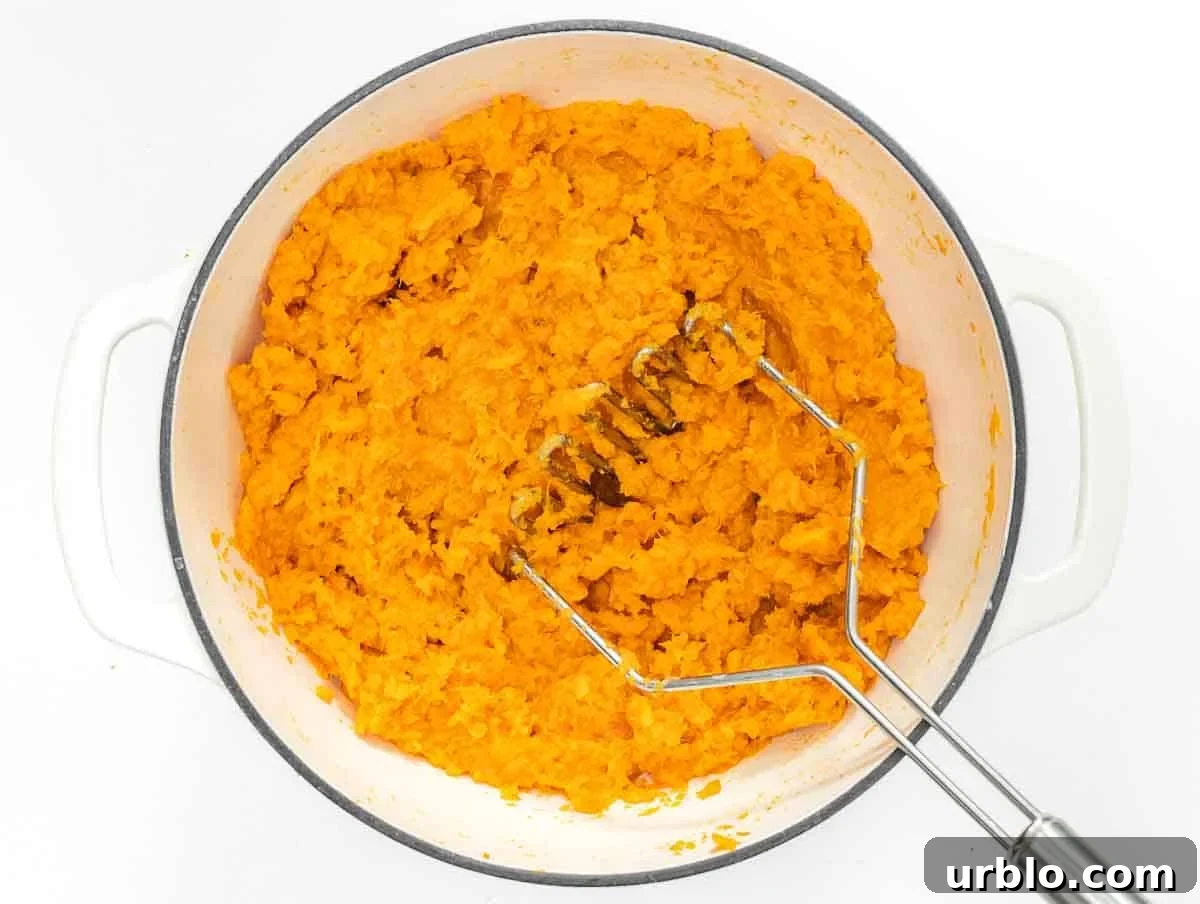 mashing sweet potatoes with a potato masher