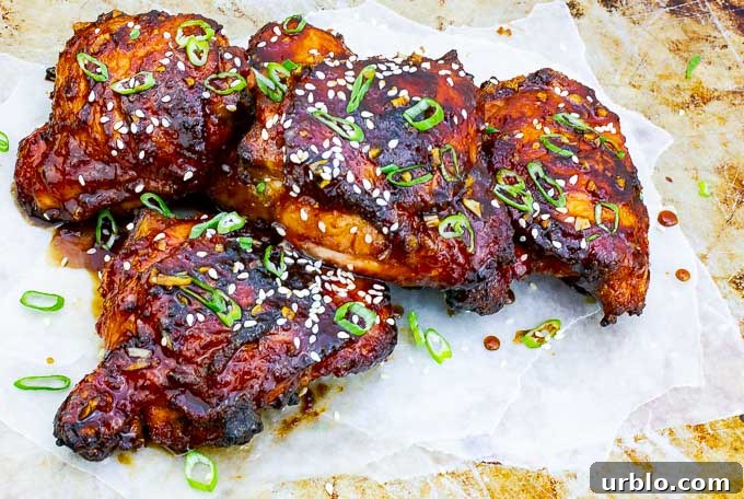 four Sticky Asian Grilled Chicken Thighs on white  and metal background
