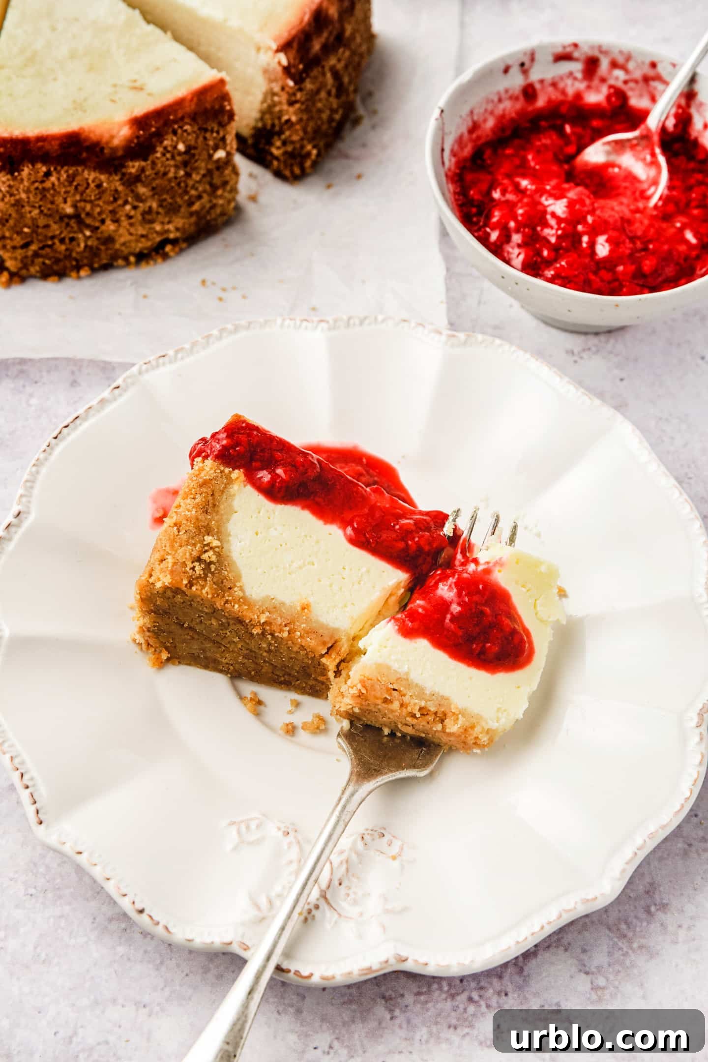 New York Cheesecake Recipe: Classic Creamy Slice Guide 8 Assiette à dessert avec une part de cheesecake et du coulis de fruits
