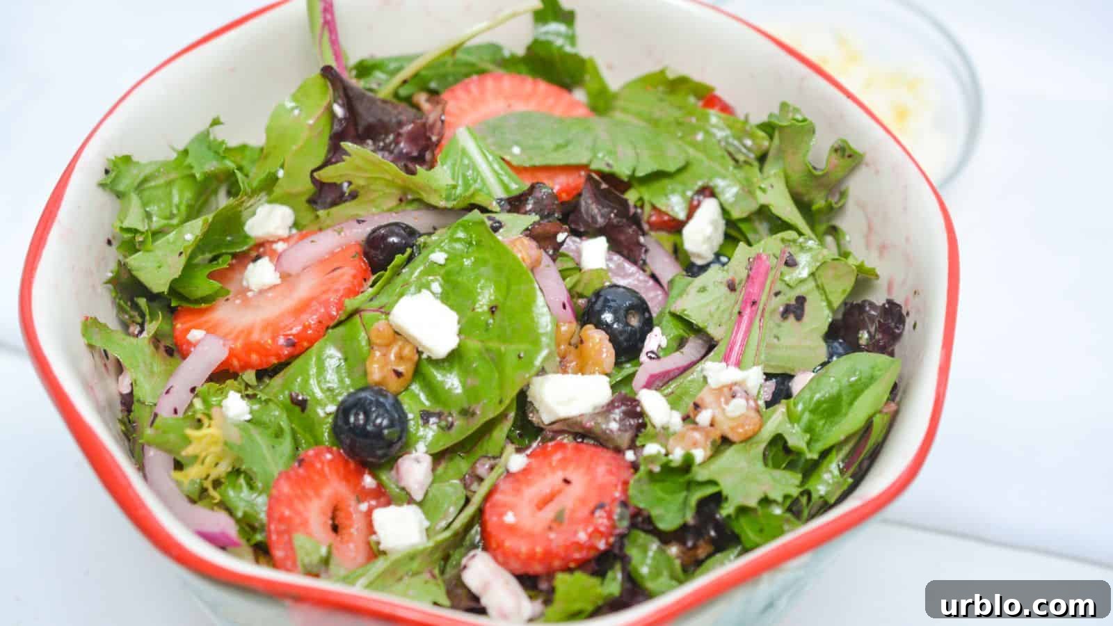 A salad with strawberries, blueberries and feta cheese.