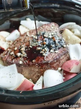 balsamic being poured over a beef roast in slow cooker