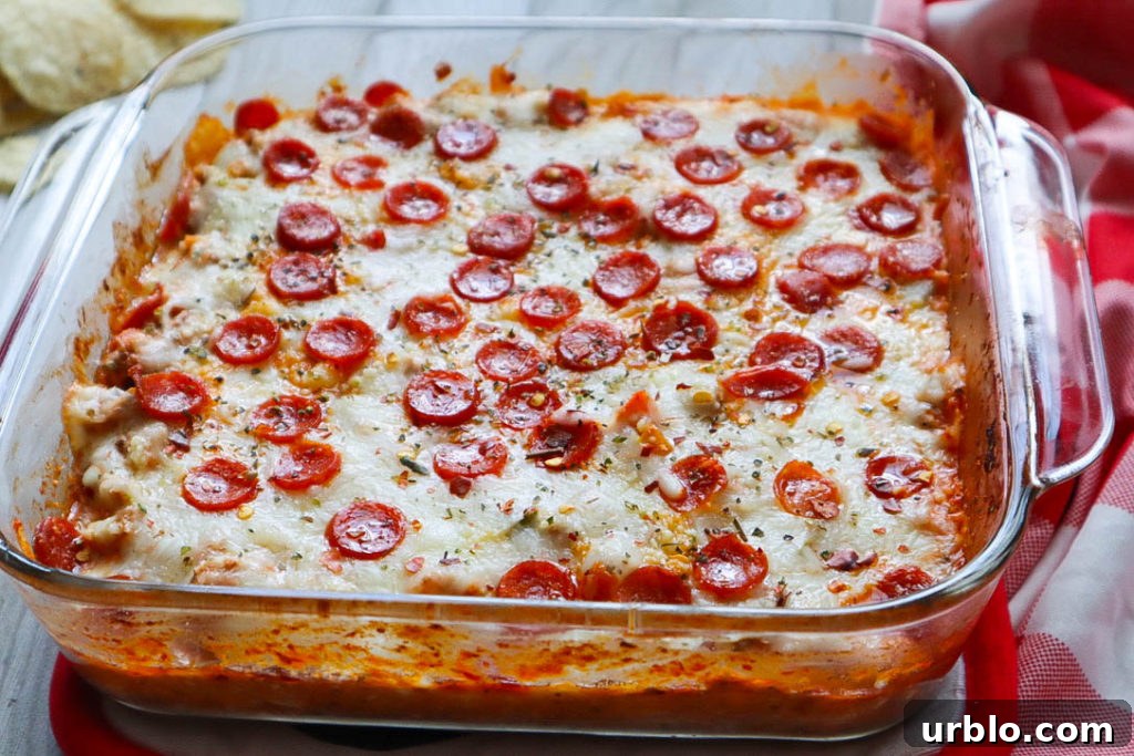 glass baking dish with pizza dip topped with melted cheese and mini pepperoni.
