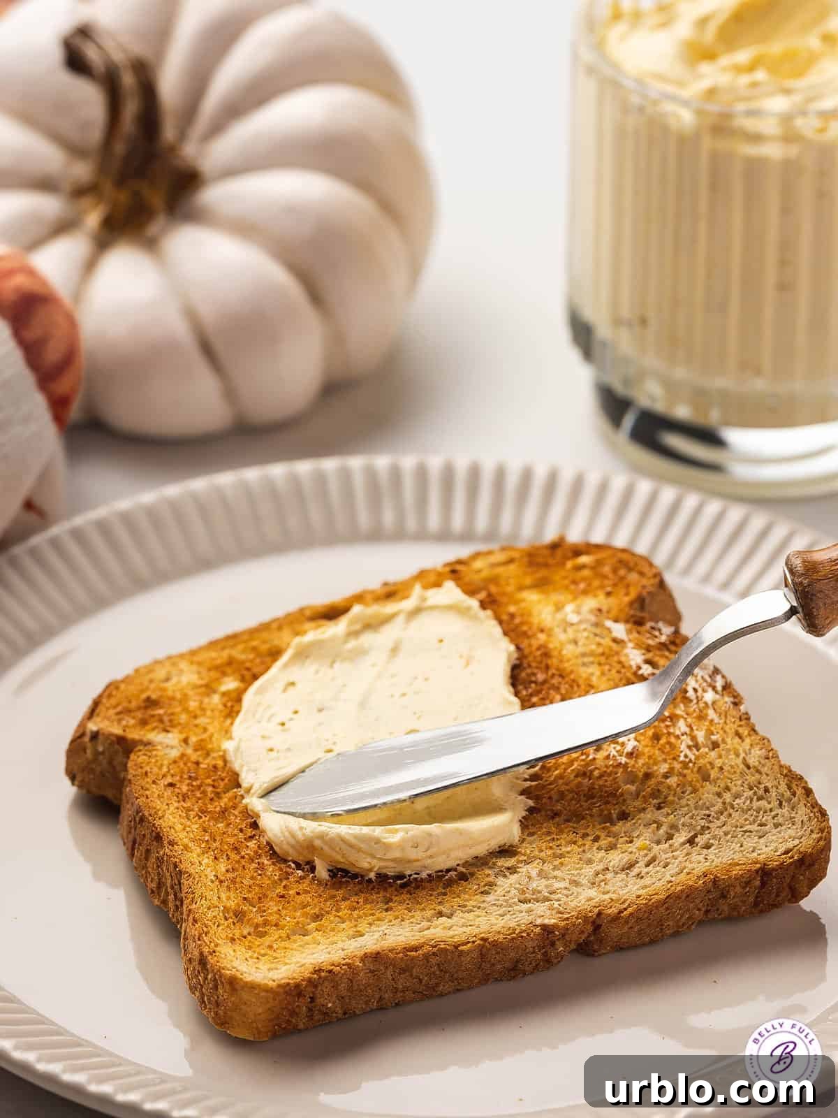 knife spreading pumpkin butter on toast