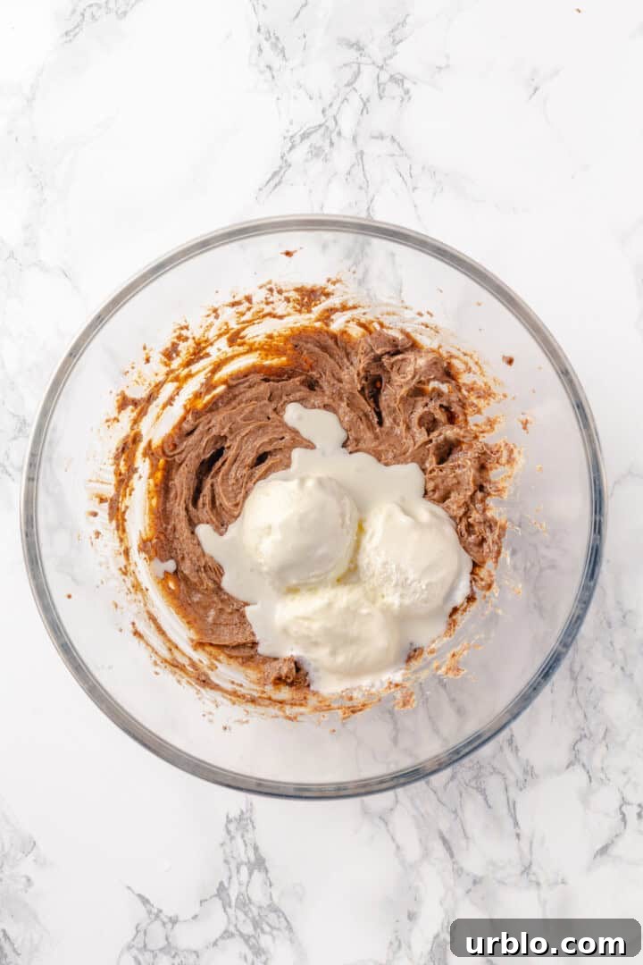 Overhead view of ice cream added to butter mixture in mixing bowl