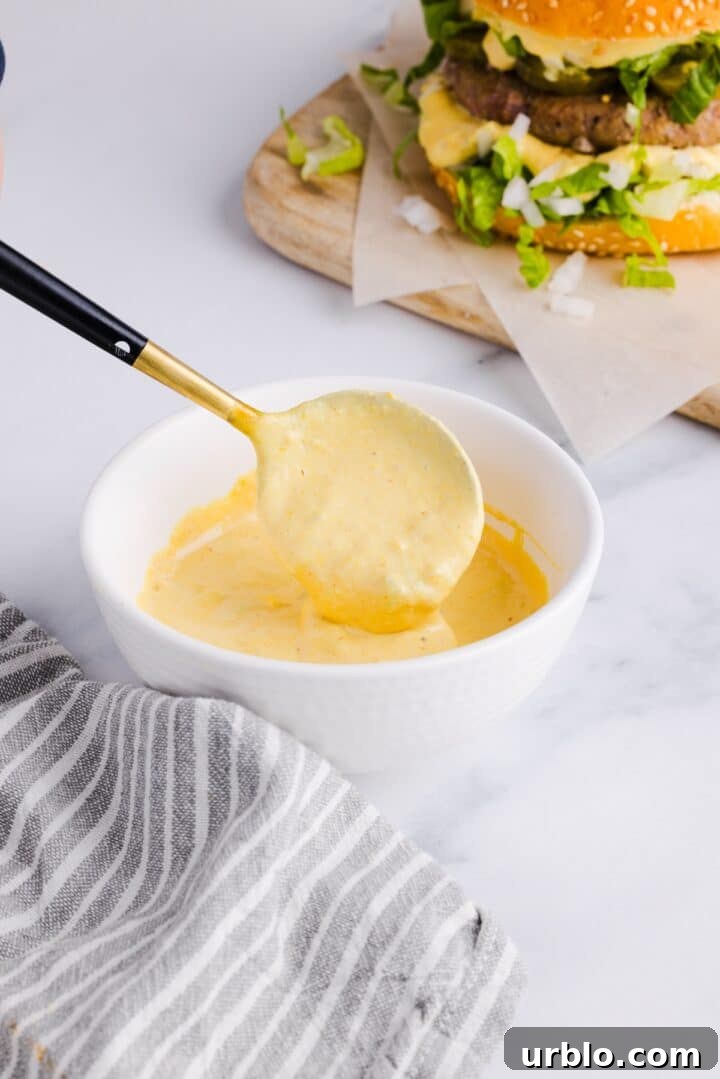 Healthy big mac sauce in a small white bowl, being spooned