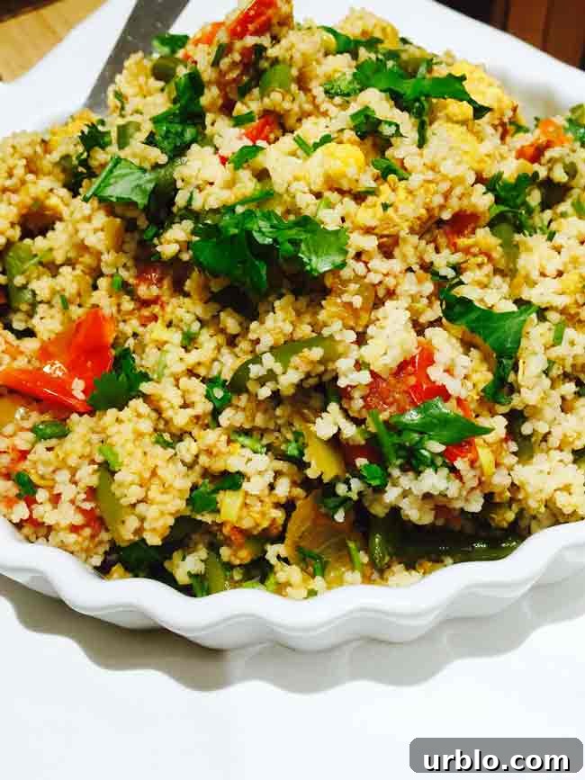 A close-up of a white plate with curried chicken couscous