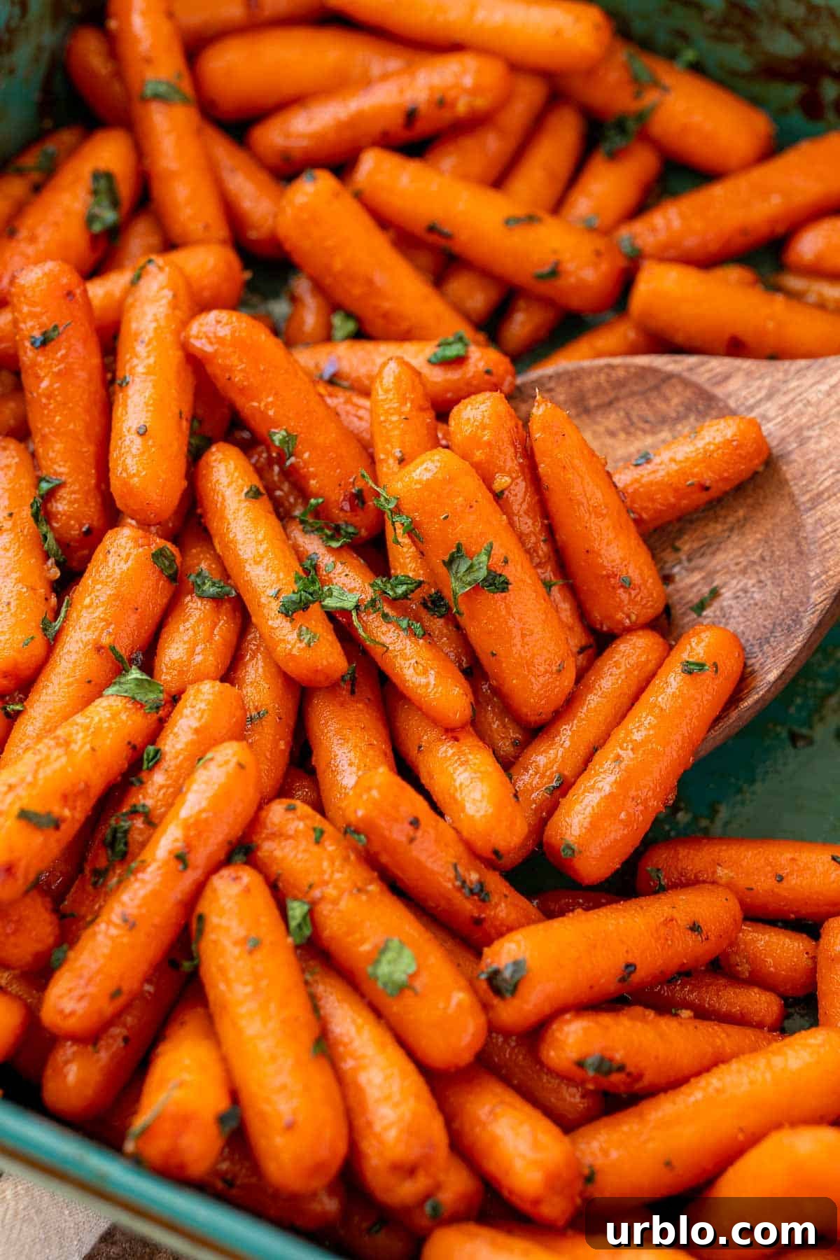 Spicy Honey-Glazed Carrots with Brown Butter and Herbs 2 Close up of roasted glazed carrots in a teal baking dish.