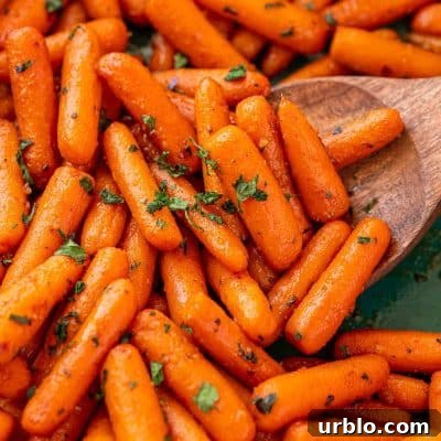 Spicy Honey-Glazed Carrots with Brown Butter and Herbs 6 Close up of roasted glazed carrots in a teal baking dish.