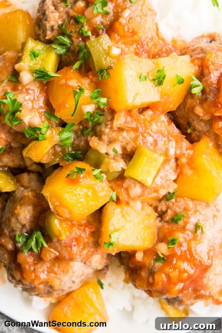 sweet n sour meatballs with pineapple bits on top of rice