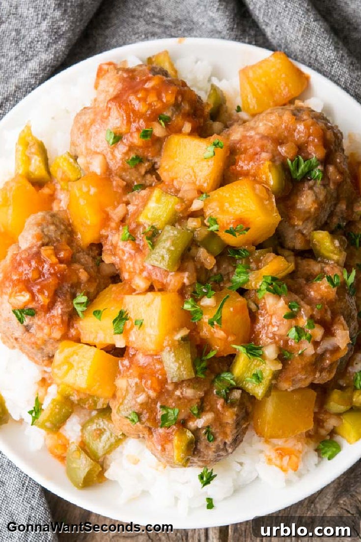 sweet and sour meatballs with pineapple bits on top of rice