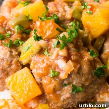sweet and sour meatballs with pineapple bits on top of rice