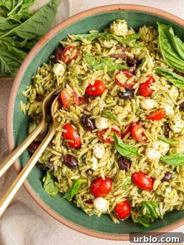 bowl of orzo pesto pasta salad with basil garnish.